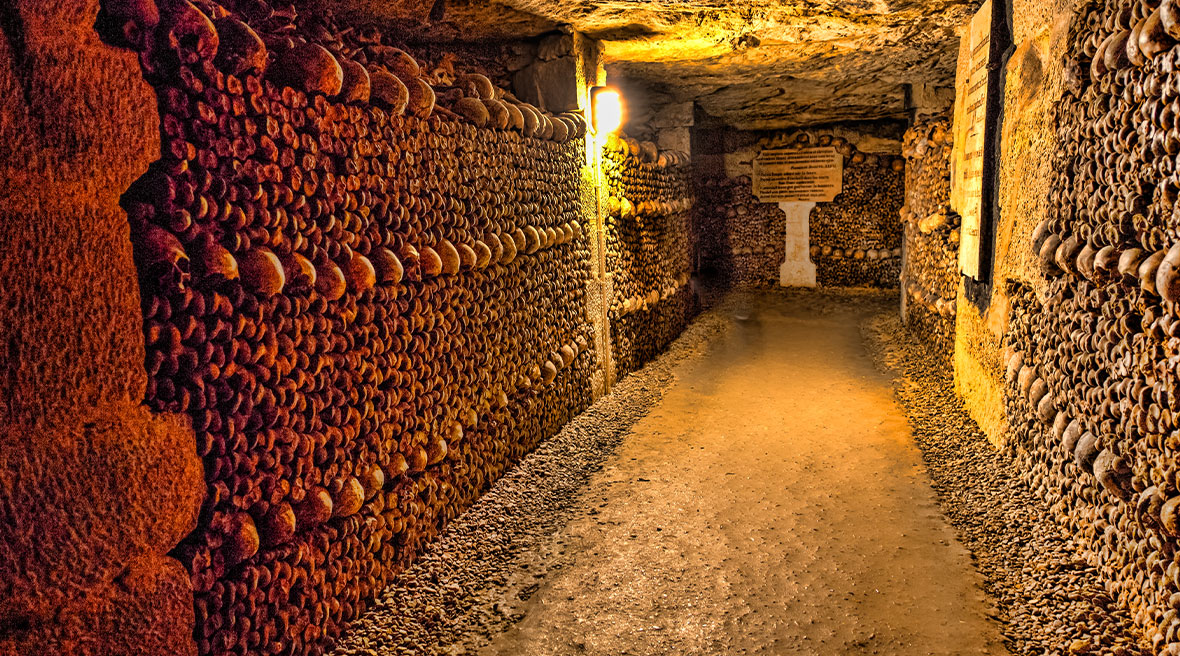 A passageway in an underground ossuary with walls lined with skulls and bones