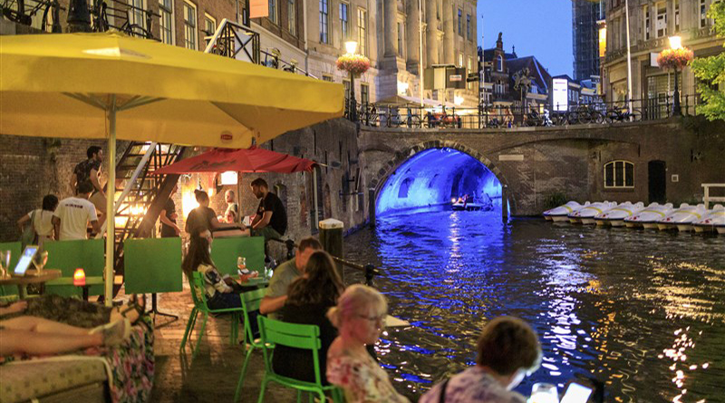 People enjoy a drink at cafes right at the water’s edge in Utrecht because of its dual-level canal streets