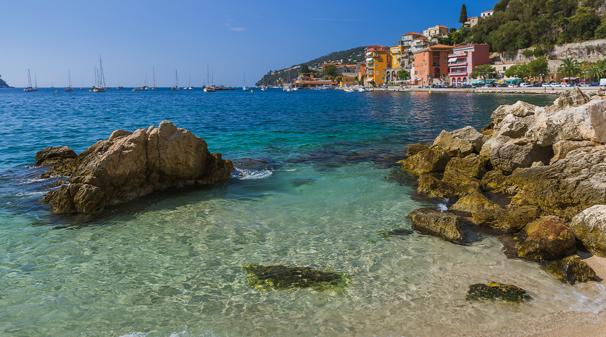 Rocky inlet with view of Villefranche town in the background and clear waters