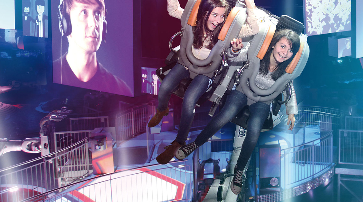 Two girls in a roller coaster type seat having fun