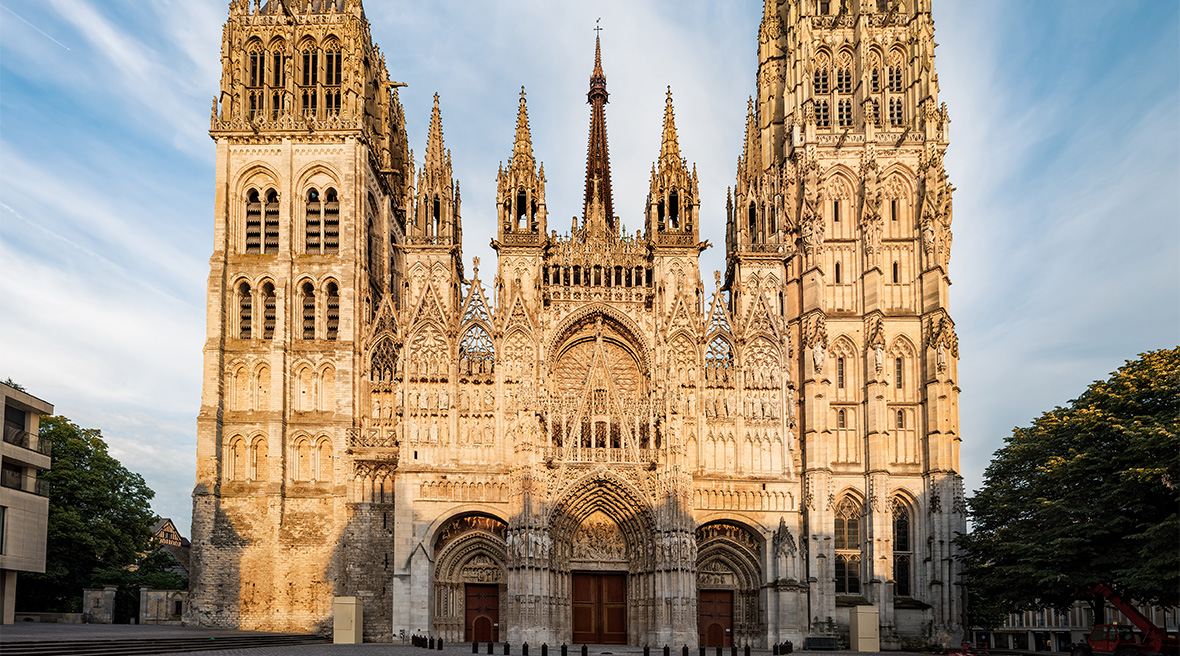 A spectacular Gothic cathedral with two towers and three entrance doors facing a large square