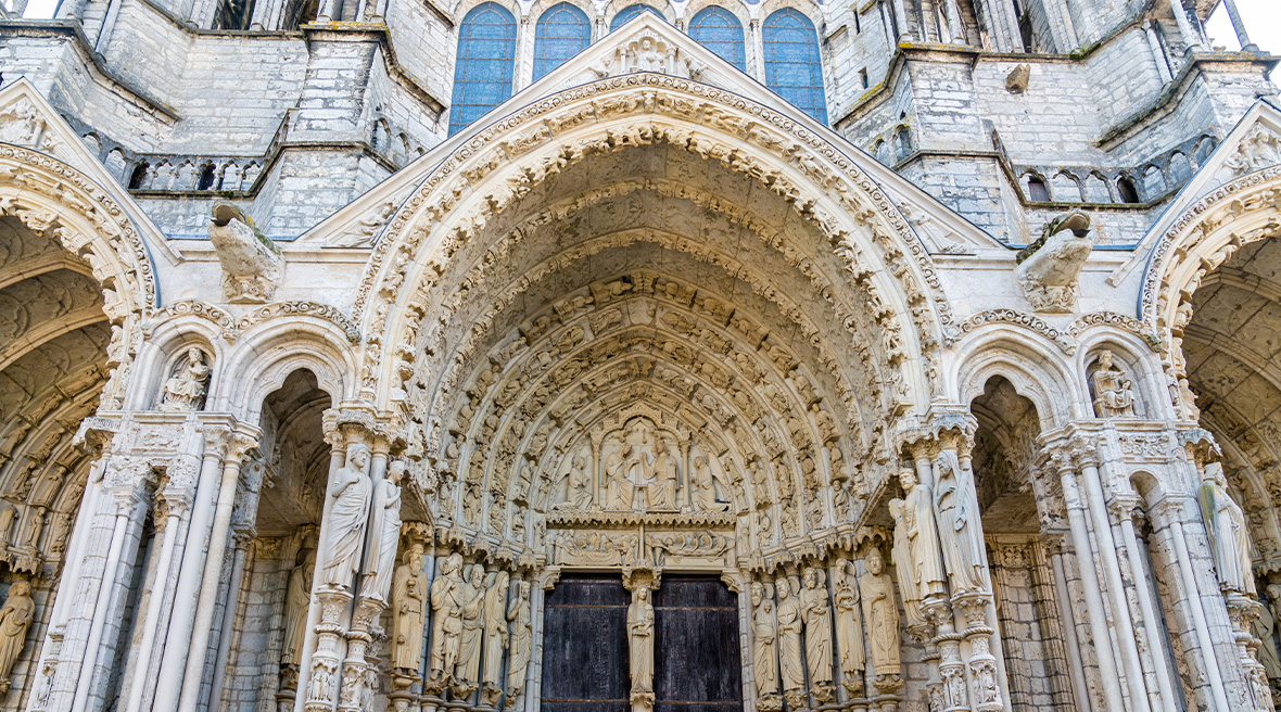 A door of a cathedral full of elaborate stone carving and many carved figures