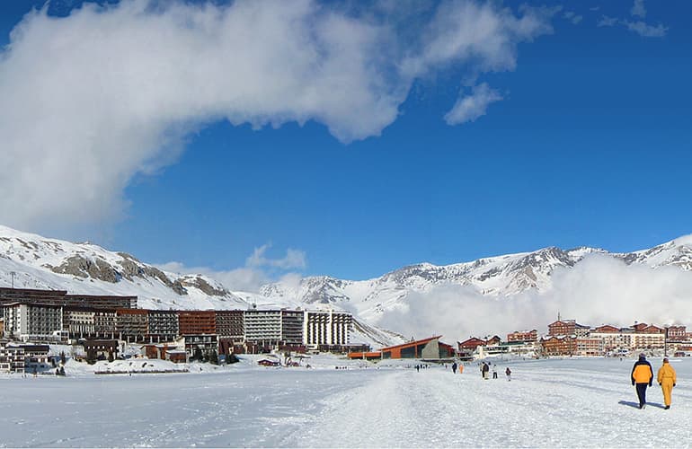 Mountain with Tignes ski resort at the base with a blue sky.